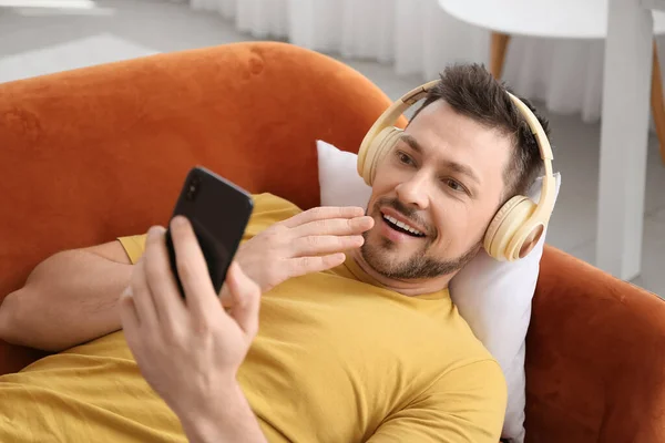 Homme Surpris Avec Téléphone Écouteurs Couchés Sur Canapé — Photo