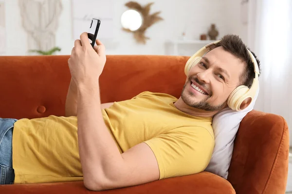 Homme Avec Téléphone Casque Couché Sur Canapé — Photo