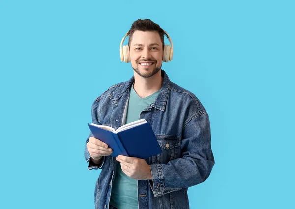 Άντρας Ακουστικά Και Βιβλίο Στο Φόντο Χρώμα — Φωτογραφία Αρχείου