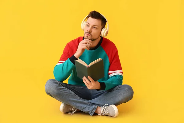 Pria Bijaksana Dengan Headphone Dan Buku Dengan Latar Belakang Warna — Stok Foto