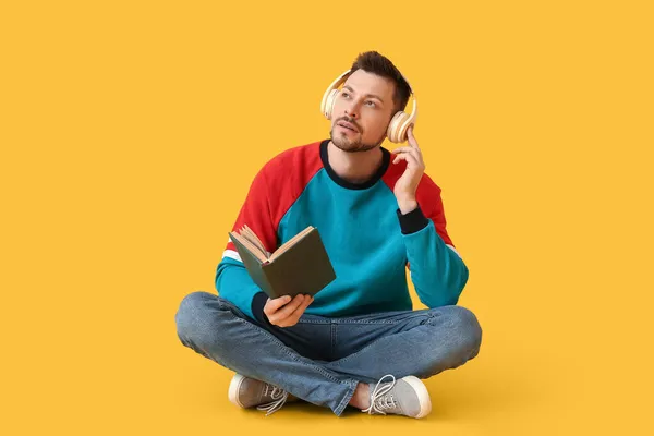 Pria Dengan Headphone Dan Buku Dengan Latar Belakang Warna — Stok Foto
