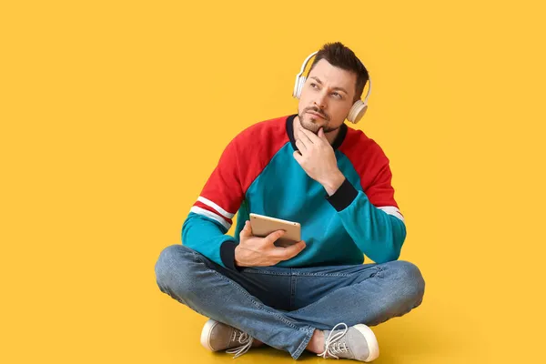 Στοχαστικός Άνθρωπος Tablet Υπολογιστή Και Ακουστικά Στο Φόντο Χρώμα — Φωτογραφία Αρχείου
