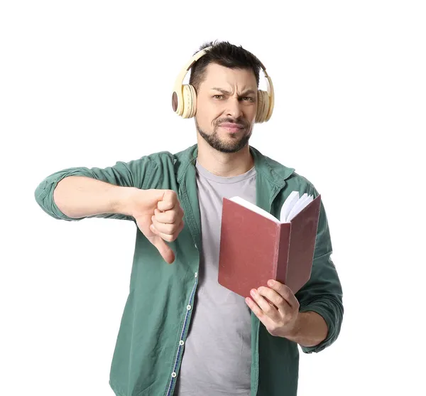 Δυσαρεστημένος Άνθρωπος Ακουστικά Και Βιβλίο Που Δείχνει Τον Αντίχειρα Προς — Φωτογραφία Αρχείου
