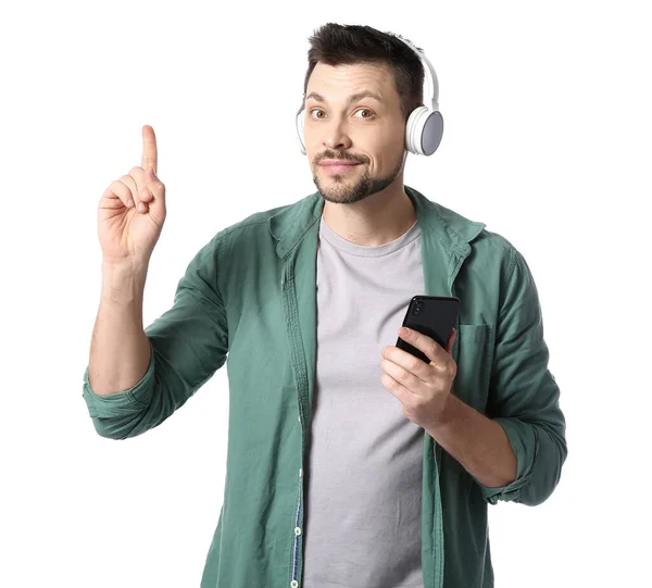 Mann Mit Telefon Und Kopfhörer Zeigt Auf Etwas Auf Weißem — Stockfoto