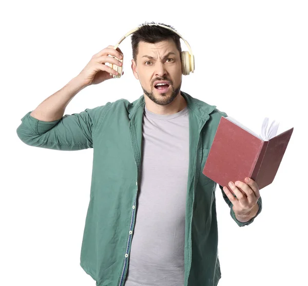 Homme Mécontent Avec Écouteurs Livre Sur Fond Blanc — Photo