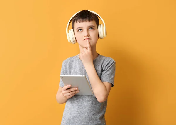 Thoughtful Little Boy Tablet Computer Headphones Color Background — Stock Photo, Image