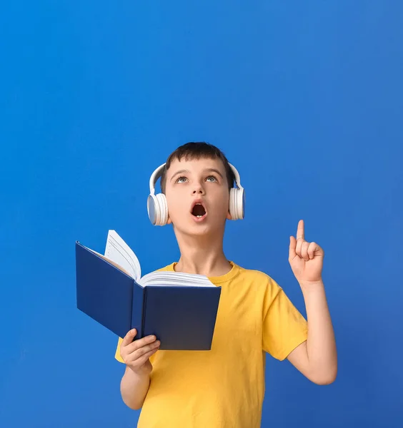 Little Boy Book Headphones Pointing Something Color Background — Stock Photo, Image