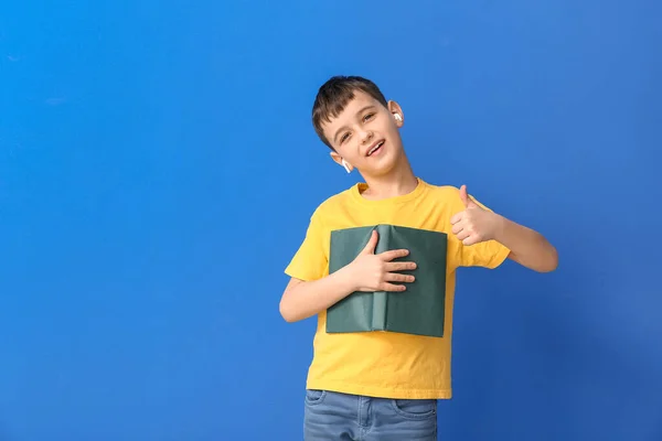 Bambino Con Libro Auricolari Che Mostrano Pollice Sullo Sfondo Colori — Foto Stock