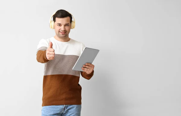 Young Man Tablet Computer Headphones Showing Thumb Light Background — Stock Photo, Image