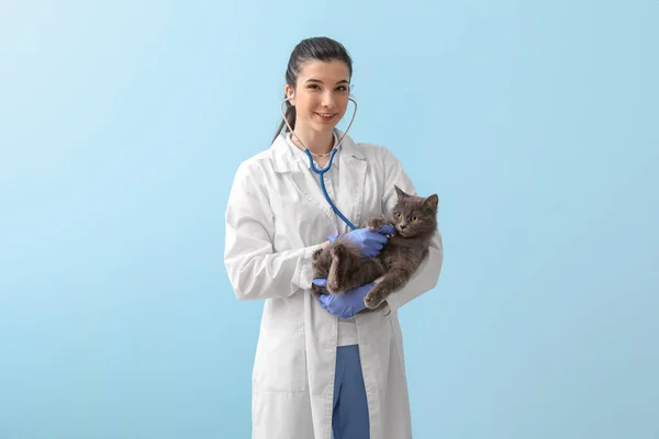 Vrouwelijke Dierenarts Onderzoeken Schattig Kat Met Stethoscoop Blauwe Achtergrond — Stockfoto