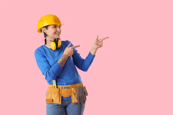 Vrouwelijke Bouwvakker Met Harde Hoed Oorbeschermers Roze Achtergrond — Stockfoto