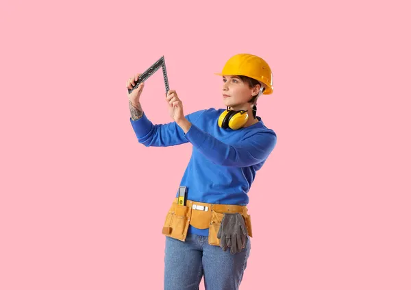 ピンクを背景に支配者と女性建設労働者 — ストック写真