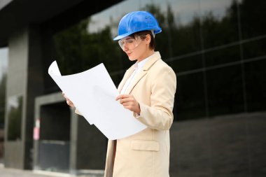 Açık hava planlı, kasketli kadın endüstriyel mühendis.