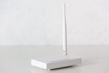 Modern wi-fi yönlendirici ışık duvarının yanındaki masada.