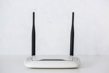 Modern wi-fi yönlendirici ışık duvarının yanındaki masada.