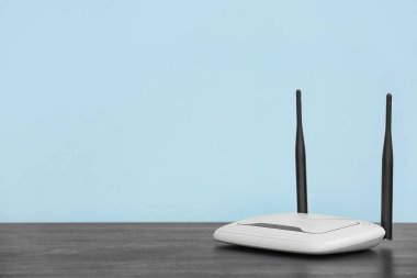 Modern Wi-Fi yönlendirici mavi duvarın yanındaki masada.
