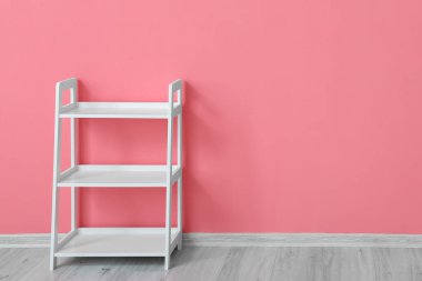 Renk duvarı yanında şık raf ünitesi