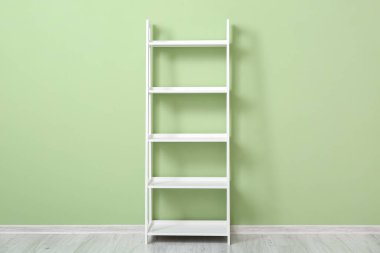 Renk duvarının yanında şık beyaz raf ünitesi