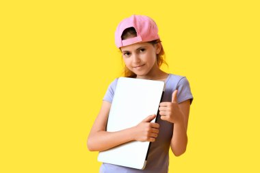 Dizüstü bilgisayarı olan küçük programcı renk arkaplanında başparmak yukarı gösteriyor