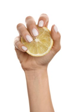 Güzel manikürlü bir kadın beyaz arka planda dilimlenmiş limon tutuyor.