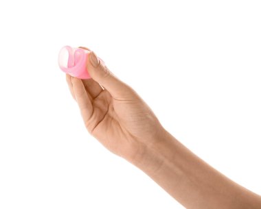 Beyaz arka planda regl bardağı olan bir kadın el.