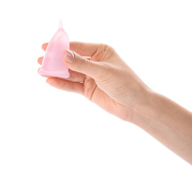 Beyaz arka planda regl bardağı olan bir kadın el.