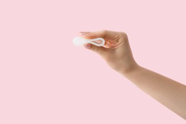 Pembe arka planda regl bardağı olan bir kadın.