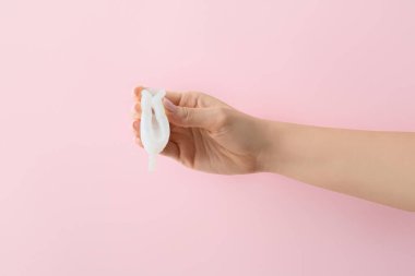 Pembe arka planda regl bardağı olan bir kadın.