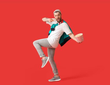 Arka planda patlamış mısır pozu veren genç adam.