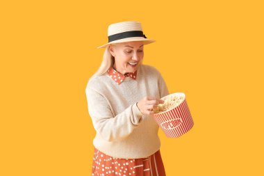 Renkli lezzetli patlamış mısırlı olgun bir kadın.