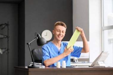 Klinikteki masada bandajlı bir erkek tıp asistanı.