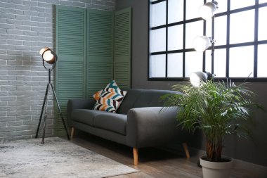 Karanlık oturma odasının içinde parlayan lambalar var.