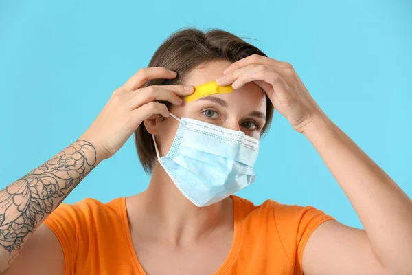 Jovem Mulher Máscara Médica Aplicando Gesso Testa Fundo Azul — Fotografia de Stock