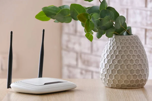 Moderner Wlan Router Und Vase Mit Eukalyptuszweigen Auf Dem Tisch — Stockfoto