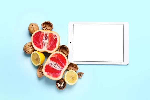 Digital recipe book, walnuts, grapefruit and lemon on color background