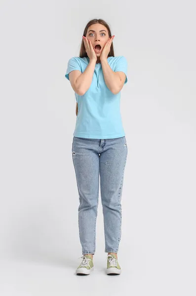 Mujer Joven Conmocionada Camiseta Azul Sobre Fondo Claro —  Fotos de Stock
