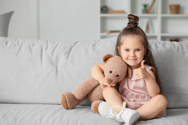 Söt Liten Flicka Med Nalle Som Visar Tummen Upp Hemma — Stockfoto