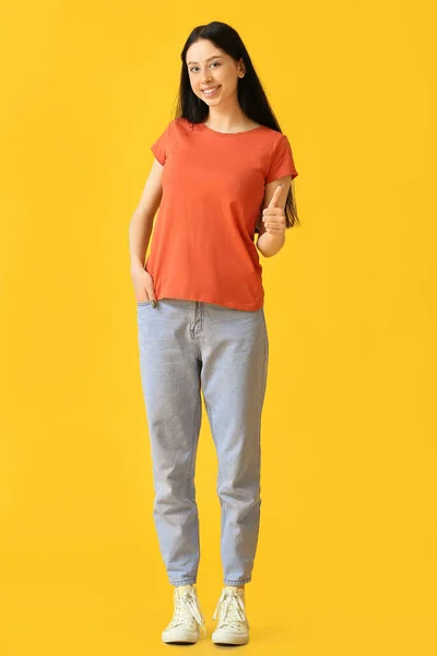 Mooi Tiener Meisje Oranje Shirt Tonen Duim Gele Achtergrond — Stockfoto