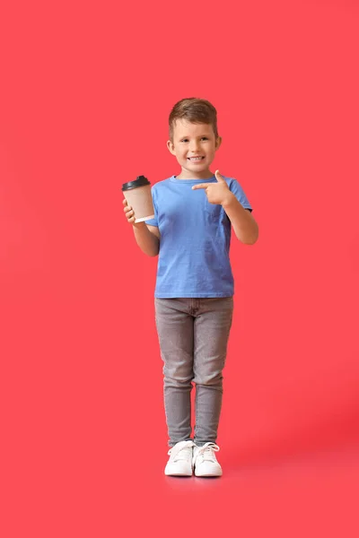 Menino Bonito Apontando Para Tomar Uma Xícara Café Fundo Vermelho — Fotografia de Stock