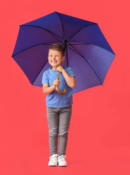 かわいいです男の子ともにオープンブルーの傘上の赤い背景 — ストック写真