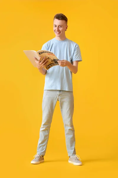 Jovem Leitura Revista Fundo Amarelo — Fotografia de Stock