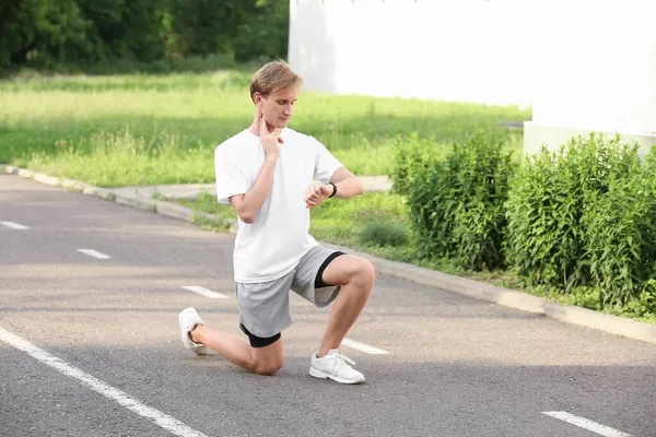 体格敏捷的男子跑步者在室外检查脉搏 — 图库照片