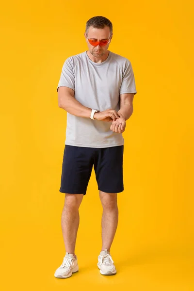 Männlicher Läufer Überprüft Puls Auf Farbigem Hintergrund — Stockfoto
