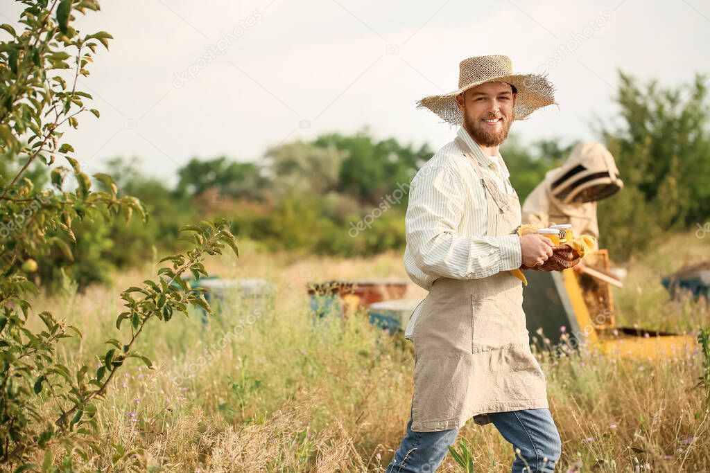 Beekeeper with honey at apiary