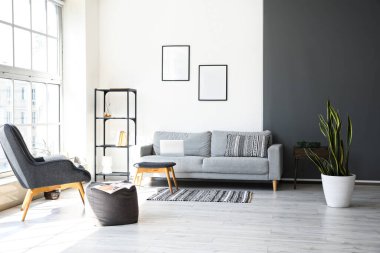 Çerçeveli ve kanepeli oturma odasının içi.