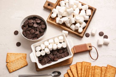 S 'mores hazırlamak için gereken malzemeler ışık arkaplanında dibe vurur