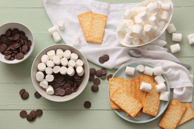 S 'mores hazırlamak için gereken malzemeler ahşap renklere daldırılıyor