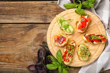 Ahşap arka planda lezzetli vejetaryen bruschetaları olan bir pano.
