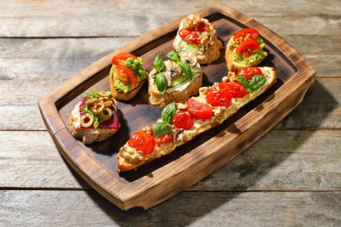 Ahşap arka planda farklı lezzetli vejetaryen bruschetalara sahip tahta.