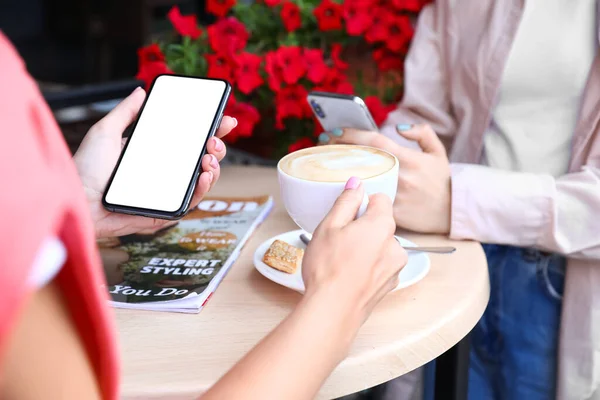 Kobiety Korzystające Telefonów Komórkowych Pijące Cappuccino Kawiarni Zbliżenie — Zdjęcie stockowe